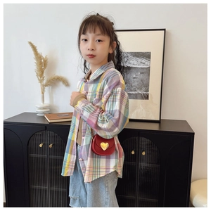 Détail d'une chemise à carreaux pour enfant avec un sac à boucle en forme de cœur rouge