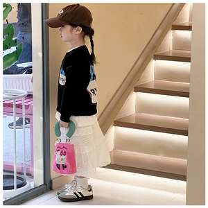 Detail der rosa Cartoon-Handtasche aus Canvas kombiniert mit einem Freizeitoutfit
