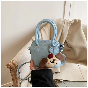 Detail of light blue pebble leather mini handbag with a cute puppy plush charm