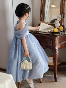 Detail of elegant girls' light blue princess dress with pearly woven handbag accessories