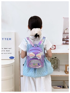 Dettaglio dello zaino viola con paillettes per bambini con grande fiocco e finestra rotonda