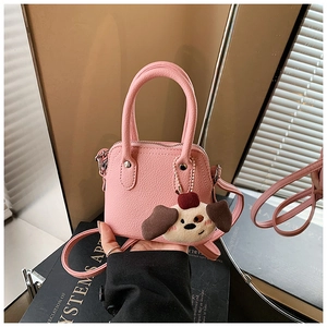Pink mini crossbody handbag for girls with cute cartoon puppy pendant and pebble leather texture