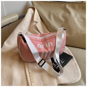 Detailed shot of pink crossbody bag with white stripes and adjustable shoulder strap