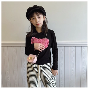 Détail du t-shirt noir enfant à manches longues avec écusson cœur rose effiloché