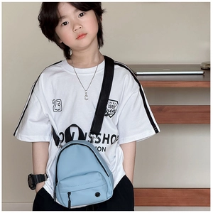 Gros plan d'un sac bandoulière enfant bleu clair avec sangle noire réglable sur modèle