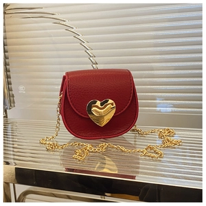 Détail du mini sac en cuir grainé rouge avec boucle cœur dorée et bandoulière chaîne