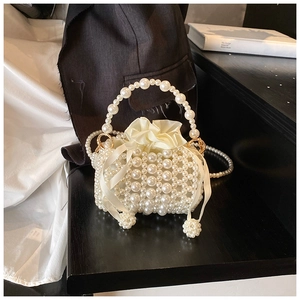 Detail of beaded pearl handbag with cream satin drawstring lining and ribbon bow