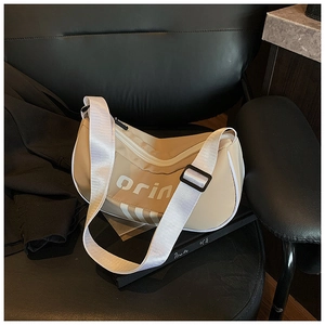 Close-up of beige nylon crossbody bag with orin letter print on a black leather chair