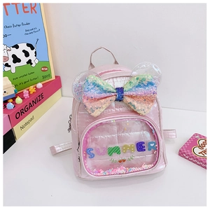 Dettaglio dello zaino rosa glitterato laser con fiocco arcobaleno e orecchie di paillettes