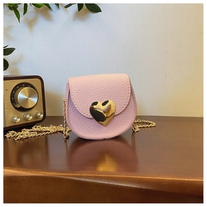 Détail du sac bandoulière enfant en cuir rose avec fermoir coeur doré et bandoulière chaîne