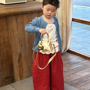 Mini gold girl's handbag with bear charm, blue knit cardigan, and red polka dot pants