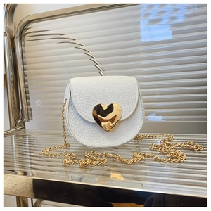 Vue macro d'un mini sac blanc en cuir grainé avec fermoir cœur doré et bandoulière chaîne