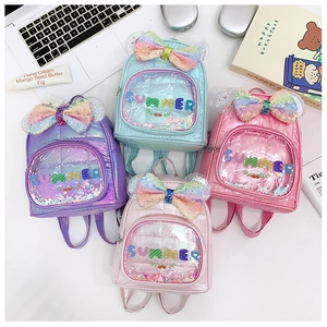 Dettaglio di zaini per bambini con paillettes colorate, fiocchi glitter e scritte estive