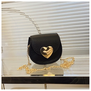 Gros plan sur le mini sac en cuir noir avec boucle cœur dorée et bandoulière chaîne