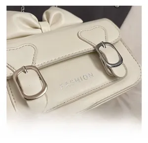 Détail du sac fille en cuir PU blanc crème avec boucle argentée et nœud décoratif