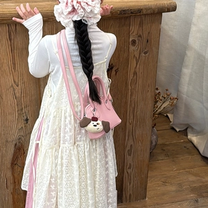 Pink mini crossbody bag for girls with cute plush dog pendant in a warm lifestyle setting