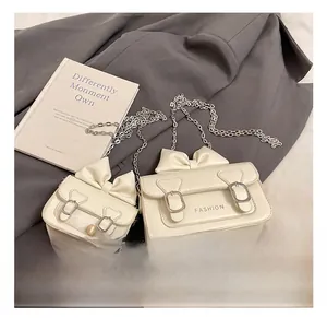 Détail de mini sacs blancs à chaîne pour filles avec nœuds élégants et texte fashion