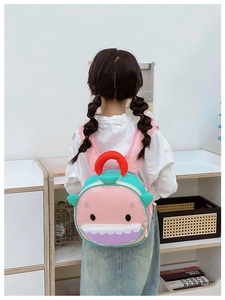 Toddler cartoon shark backpack with cute pink and teal design worn by a child