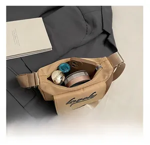 Internal capacity of khaki nylon crossbody bag showing smartphone and cosmetics storage