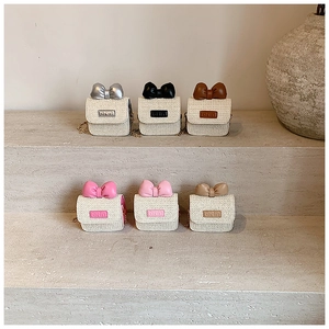 Detail of colorful woven mini crossbody bags with leather bows on stone stairs