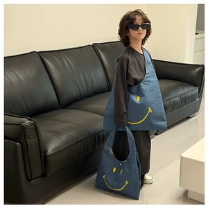 Close-up of blue canvas kids tote bags featuring yellow smiley faces in multiple sizes