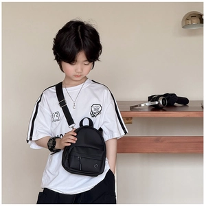 Détail de la sacoche noire pour enfant avec poche zippée et bandoulière réglable