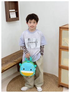 Detail of cartoon shark backpack for kids with green handle and zipper closure in blue