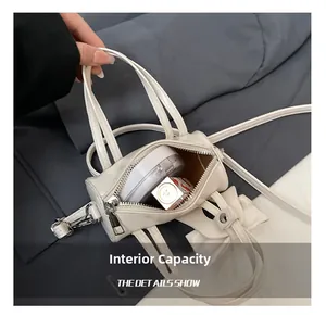 Internal capacity of mini white cylinder bag showing space for lipstick and compact
