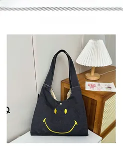 Detail of dark denim toddler tote bag with yellow smiley embroidery and magnetic snap