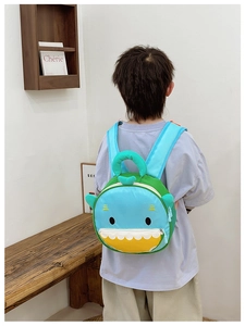 Toddler backpack featuring a cute blue shark design worn by a child in a home setting