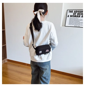 Detail view of child wearing cartoon car shaped crossbody bag with adjustable strap