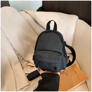 Détail d'un mini sac bandoulière noir en nylon avec poche frontale et bandoulière réglable