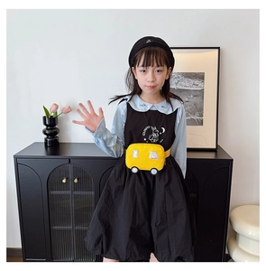 Detail view of children's yellow cartoon car waist bag paired with a blue long sleeve shirt