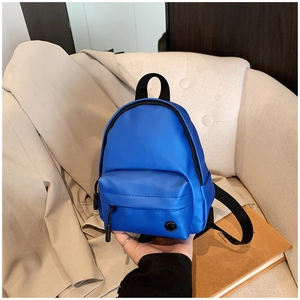 Détail d'un mini sac à bandoulière bleu vif en tissu résistant avec fermetures noires