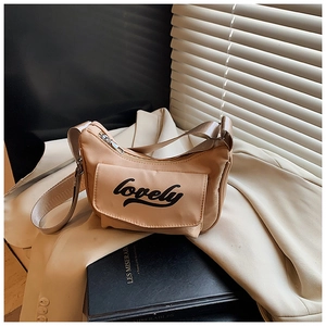 Detail of light brown nylon crescent crossbody bag with lovely lettering on a blazer