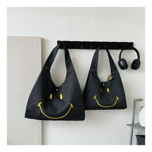 Detail of two dark gray canvas smiley face tote bags in different sizes with headphones