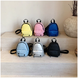 Vue détaillée de mini sacs à bandoulière en nylon en six couleurs sur un socle