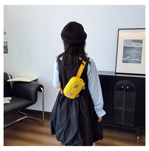 Detail of cute yellow car-shaped canvas chest bag for kids with adjustable shoulder strap