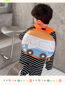 Detail of cute orange bus-shaped hard shell kids backpack worn by a toddler child
