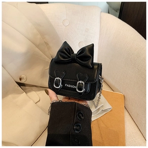 Détail d'un mini sac noir en cuir PU avec un grand nœud et lettrage fashion élégant