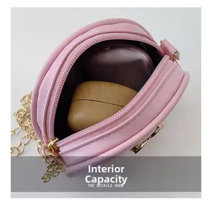 Détail de la capacité interne du mini sac bandoulière rose avec chaîne dorée et trèfle