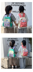 Detailed view of color-block kids backpack with front zipper pocket and nylon texture