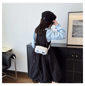 Detail of white canvas crossbody bag with colorful square patches and adjustable strap
