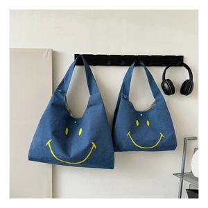 Blue denim tote bags with yellow smiley face hanging in a modern home interior