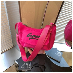 Detail of hot pink crossbody bag with love print and wide fabric shoulder strap