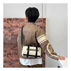 Détail du sac cylindrique blanc cassé pour garçons avec lettrage noir FASHION tendance