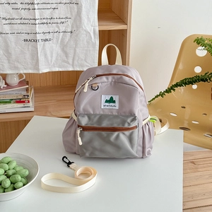 Detail of durable nylon kids backpack showing lavender body and gray front pocket zippers