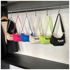 Close-up of colorful nylon messenger bags with adjustable straps hanging on a display
