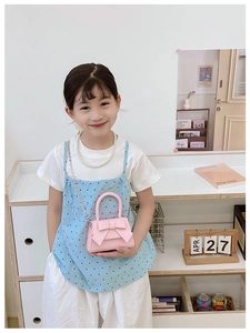 Pink mini crossbody bag for girls with a large bow detail and metal chain strap