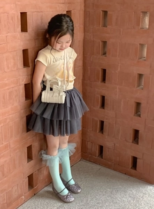 Close-up of a white cylinder mini bag with bow decoration on a young girl model